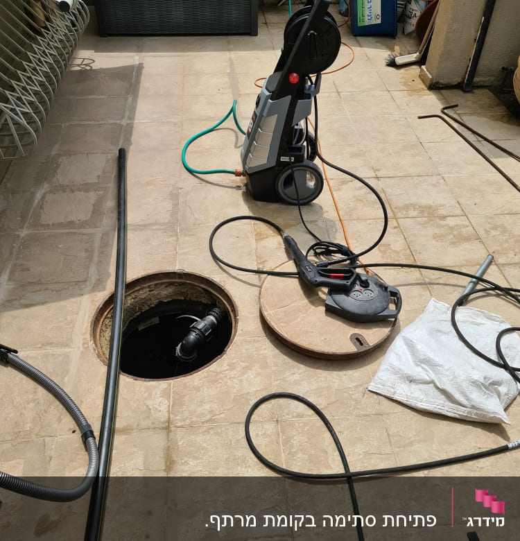 כלי עבודה וצינורות ליד פתח ביוב פתוח